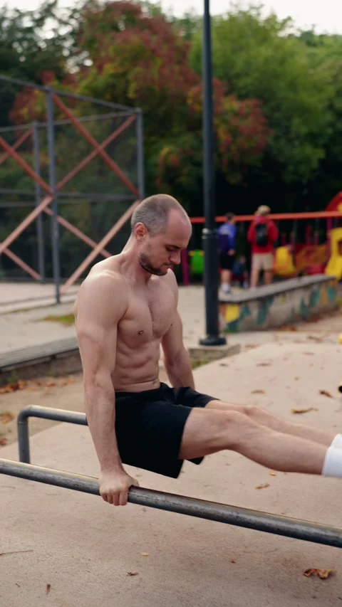 Muscular Man Doing Dips on Parallel Bars in a Park Video stock 310685150