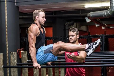 Muscular man doing exercises on parallel bar Stock Photos