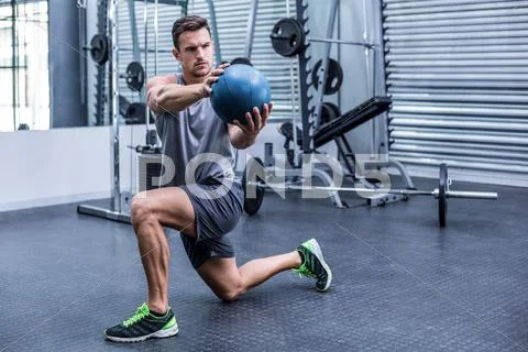 Muscular man doing medecine ball exercises Stock Photos