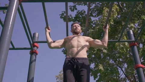 Muscular man doing pull-ups on horizontal bar Stock Footage 79051999