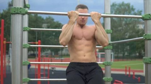 Muscular man doing pull-ups on horizontal bar during his workout 動画素材 116332822