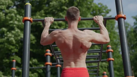 Muscular man doing pull ups on sports ground Stock Footage 244201325