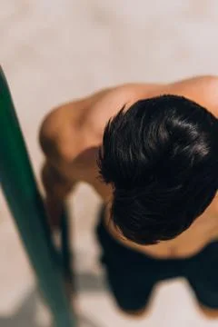 Muscular man doing pull-ups on horizontal bar 库存照片