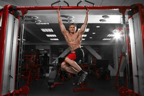 Muscular man doing pulling up on horizontal bar. Stock Photos
