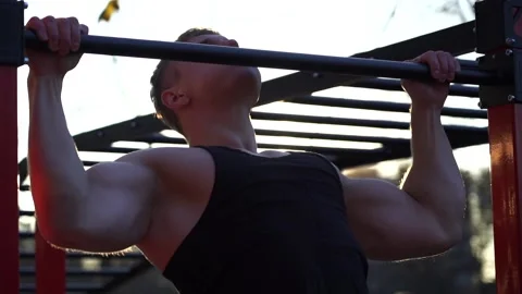 Muscular man doing pullups on sunset sky background. Calisthenics, healthy Stock Footage 167244680