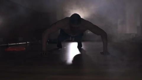Muscular man doing push up exercises in the gym. Smoke at the backlight. Stock Footage 89099600