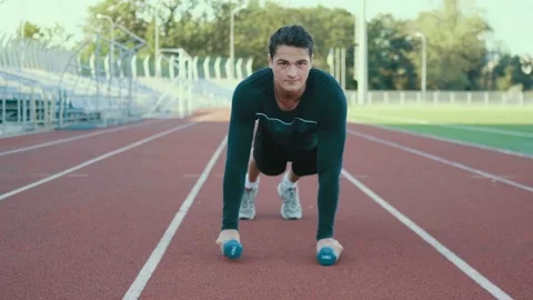 Muscular man doing push up exercises with dumbbell in the stadium. 4K. Stock Footage 125417706