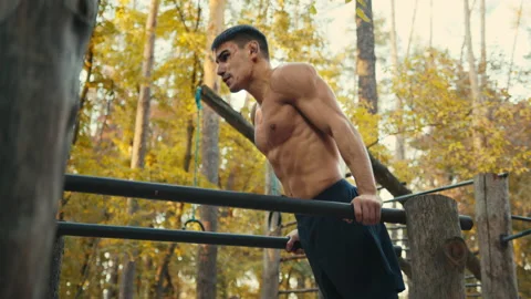 Muscular man doing push ups exercises on parallel bars. Man with naked torso Stock-Footage 165276846