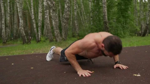 Muscular Man Doing Push-ups in an Outdoor Park 스톡 동영상 329599236