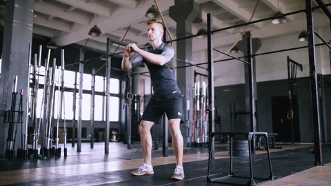 Muscular man doing slight crouch or squats Stock Footage 114972312