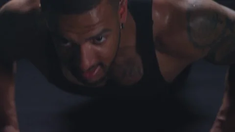 Muscular man doing some push ups, and maintaining his position Stock Footage 77428003