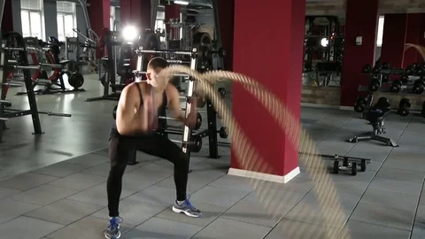 Muscular man doing waves with undulation ropes Vídeos de archivo 73931815