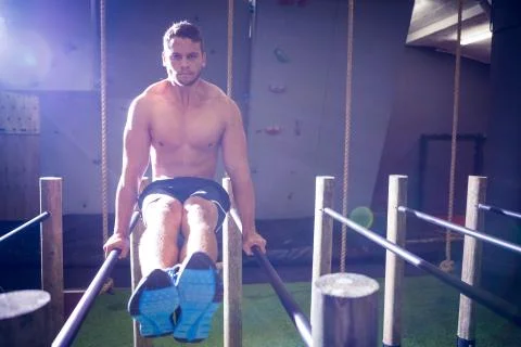 Muscular man exercising on parallel bars Stock Photos