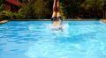 Muscular Man Jumping into the Blue Water in Outdoor Pool near Luxury Resort. HD Footage