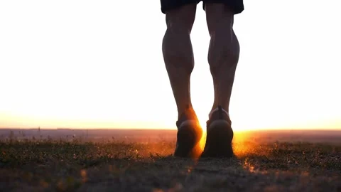 A muscular man jumping over the rope on the field at sunset Stock Footage 219955294
