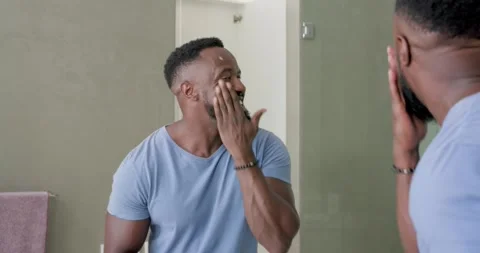 Muscular man opening jar, applying moisturizer at bathroom vanity, checking Stock Footage 336438123