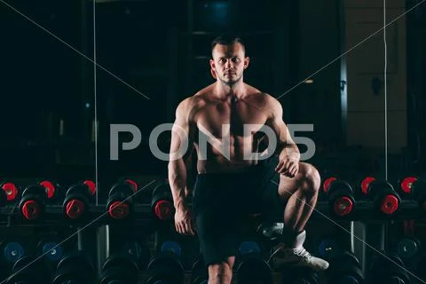 Muscular man out in gym standing near dumbbells , strong male naked torso abs Stock Photos