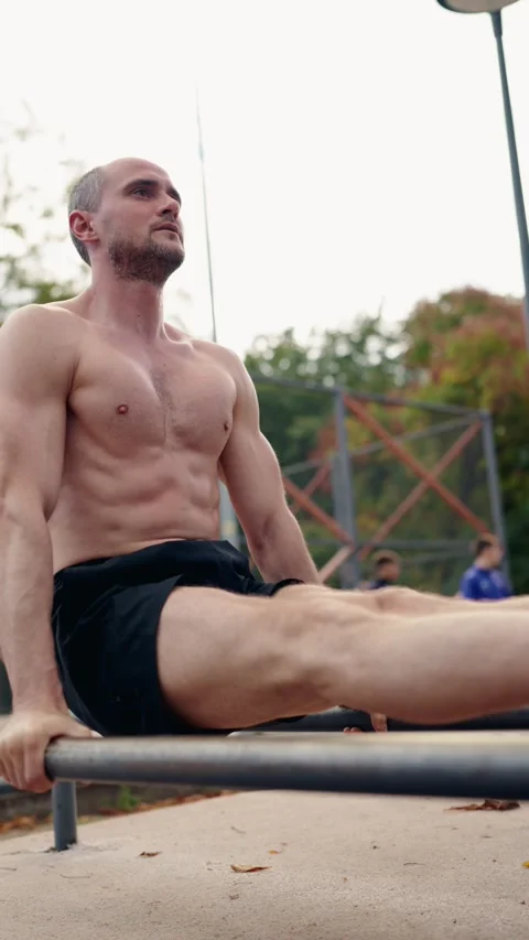 Muscular Man Performing Dips on Parallel Bars at Outdoor Gym Stock Footage 313500530