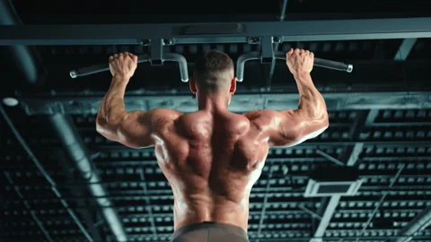 Muscular Man Performing Pull-Ups on Horizontal Bar in Modern Fitness Center Stock Footage 270485533