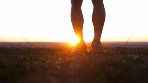 A muscular man picks up a jump rope and begins to jump over it at sunset Stock Footage 219956154