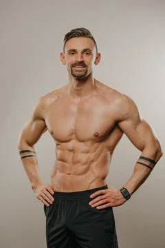 A muscular man is posing. The athletic guy is demonstrating his sporty physiq Stock Photos