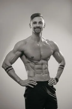 A muscular man is posing. The athletic guy is demonstrating his sporty physiq Stock Photos