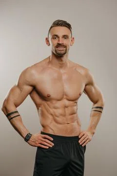 A muscular man is posing. The athletic guy is demonstrating his sporty physiq Stock Photos