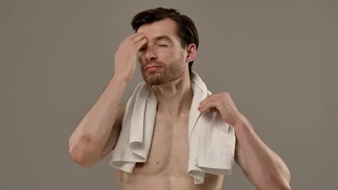 Muscular Man Posing on a Beige Background Stock Footage 310491946