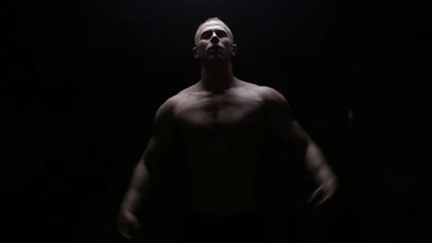 Muscular man posing in dark Stock Footage 76168176