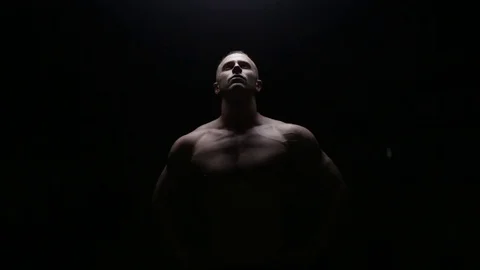 Muscular man posing in dark Stock Footage 76168180