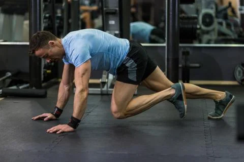 Muscular man practicing climbers exercise at the gym. Stock Photos