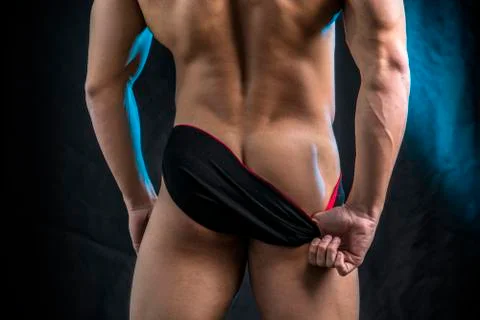 Muscular man pulling down underwear Stock Photos
