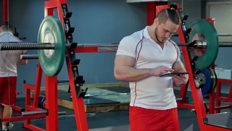 Muscular man using digital tablet during break in the gym Vidéo 74117103