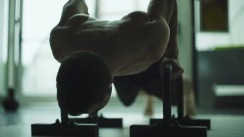 Muscular man working out on dip bars at the gym Stock Footage 127436222