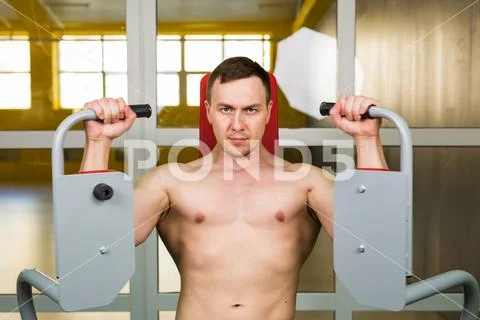 Muscular man working out in gym doing exercises, strong male naked torso abs Stock Photos