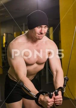 Muscular man working out in gym doing exercises, strong male naked torso abs Stock Photos