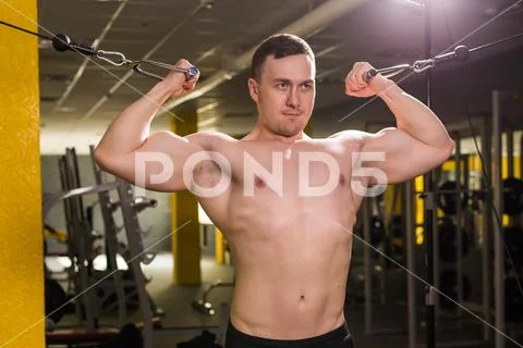 Muscular man working out in gym doing exercises, strong male naked torso abs Stock Photos
