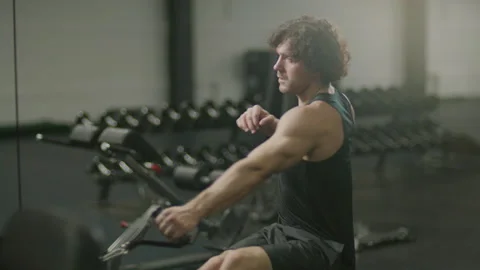 Muscular Man Working Out on Rowing Machine at Gym Stock Footage 302514930