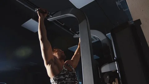 Muscular man workout pull up training hands and shoulders on weights machine Stock Footage 81962103