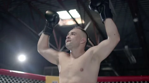 Muscular MMA fighter is inroducing himself inside the octagon and raising up his Stock Footage 155656930