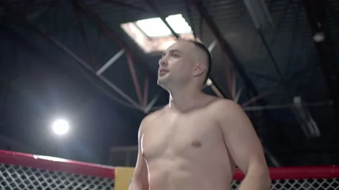 Muscular MMA fighter is inroducing himself inside the octagon and raising up his Stock Footage 155657107