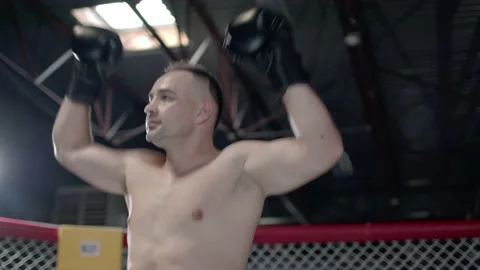 Muscular MMA fighter is inroducing himself inside the octagon and raising up his Stock Footage 155657231