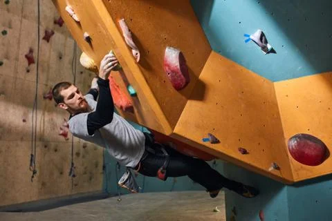 Muscular physically challenged climber moving up on steep rock Stock Photos