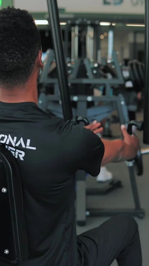 Muscular trainer performing seated cable row.Afro american personal trainer.. Stock Footage 309548563