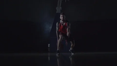 Muscular young basketball player training in the dark background with smoke Stock Footage 106938430