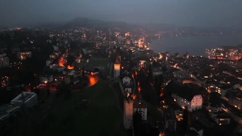 Musegg Wall and its nine towers aerial view at night overlooking glowing city in Stock-Footage 336751809