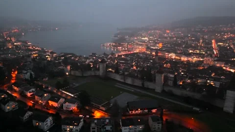 Musegg Wall and its nine towers aerial view at night overlooking glowing city in Vídeos de archivo 336752160