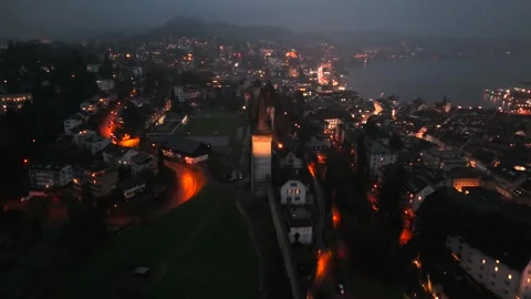 Musegg Wall and its nine towers aerial view at night overlooking glowing city in Vídeo Stock 336752266