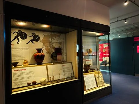 Museum display of ancient Greek artifacts and pottery in a glass case at a .. Stock Photos