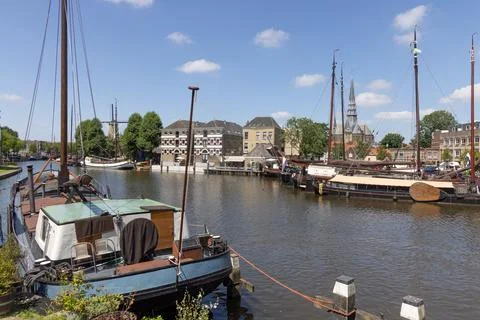 Museum harbor in Gouda featuring multiple boats moored, with historic buildin Stock Photos